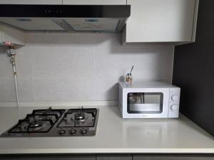 a kitchen with a microwave oven and a stove at 청라 스테이 22층 뷰 공항 송도 검단 김포 in Kojan