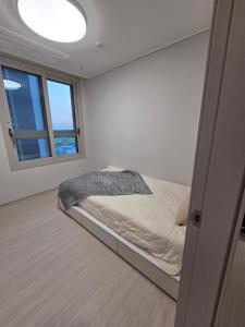 a bedroom with a bed in a room with a window at 청라 스테이 22층 뷰 공항 송도 검단 김포 in Kojan