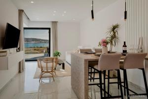 a kitchen and living room with a table and chairs at Relaxury Villa I in Karpathos