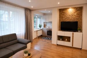 a living room with a couch and a flat screen tv at Centro apartamentai in Zarasai