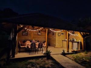 a deck with a table and chairs and lights at Kucica in Lukavac