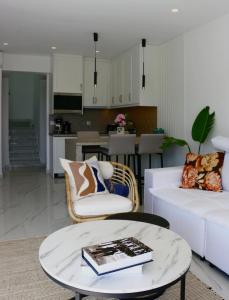 a living room with a white couch and a table at Relaxury Villa I in Karpathos