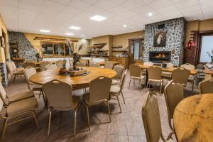 a dining room with tables and chairs and a fireplace at Pod Smerkami in Szklarska Poręba