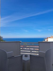a balcony with chairs and the ocean in the background at Venti Magici Rooms in Peschici