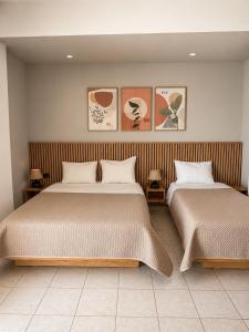two beds sitting next to each other in a bedroom at Harmonia Himara in Himare