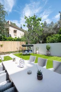 a white table and chairs in a garden at Villa Yvonni in Poros +24 photos