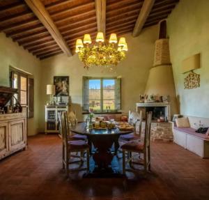 a large living room with a dining table and a chandelier at La casa di Arianna in Casole dʼElsa