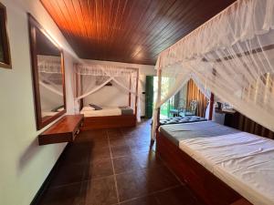 a bedroom with two beds with mosquito nets at The Cottage Sigiriya in Sigiriya +115 photos