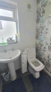 a bathroom with a white toilet and a sink at Wigston house in Wigston Magna +8 photos