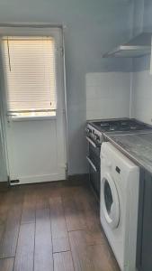 a kitchen with a stove and a washing machine at Wigston house in Wigston Magna