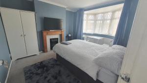 a bedroom with a bed with a fireplace and a television at Wigston house in Wigston Magna