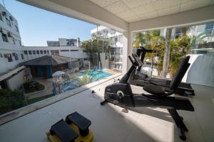 a room with a gym with a view of a pool at Scaini Palace Hotel in Arroio do Silva