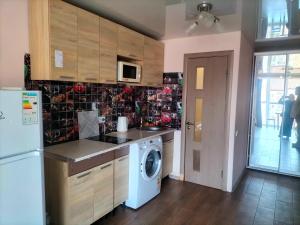 a kitchen with a refrigerator and a washing machine at Морской дом in Odesa