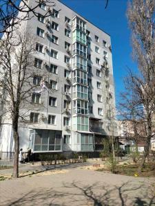 a tall apartment building with people standing in front of it at Морской дом in Odesa