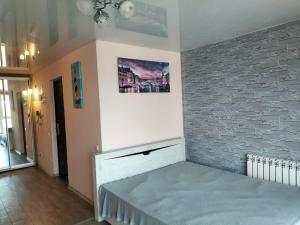 a bed in a room with a brick wall at Морской дом in Odesa