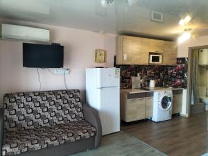 a kitchen with a couch and a white refrigerator at Морской дом in Odesa +4 photos