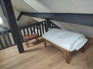 a bed and a chair on a balcony at Huma2025 in Eede