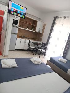a room with two beds and a kitchen with a tv at Vila Erjoni in Ksamil