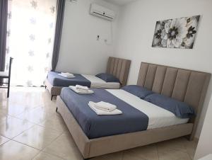 two beds in a bedroom with towels on them at Vila Erjoni in Ksamil