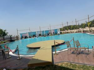 a large swimming pool with chairs in the water at Vetiver Grand in Jabalpur +26 photos