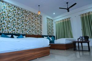 a bedroom with two beds and a wall mural at Hotel JR Palace- Near Toran Dwar and free Parking in Khātu