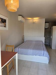 a small bedroom with a bed and a table at Apartments Estelle in Pula