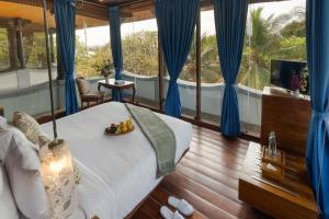 a bedroom with a bed with blue drapes at Le Dupleix in Pondicherry