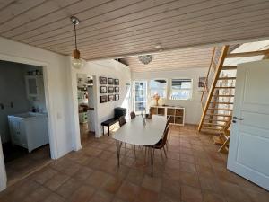 a dining room with a table and a kitchen at Guesthouse Villa Sønderklit in Skagen