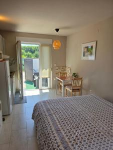 a bedroom with a bed and a kitchen and a table at Apartments Estelle in Pula