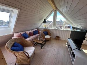 a living room with two couches and a tv at Guesthouse Villa Sønderklit in Skagen