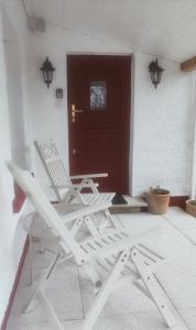 two white lawn chairs sitting on a porch at The Home House in Plumb Bridge +38 photos