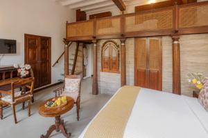a bedroom with a large bed and a desk at Le Dupleix in Pondicherry