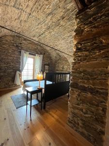 a room with a stone wall and a bed and a table at Domaine Santa Petronilla "chapelle" in Rogliano +8 photos
