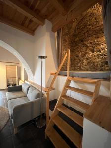 a living room with a couch and a stone wall at Domaine Santa Petronilla "chapelle" in Rogliano