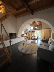a living room with a couch and a table at Domaine Santa Petronilla "chapelle" in Rogliano