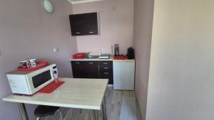a small kitchen with a microwave on a table at Apartament u Basi in Gdańsk +3 photos