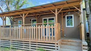 a wooden cabin with awning on a deck at Campeggio Amici di Lazise in Lazise