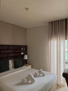 a bedroom with a large bed with towels on it at Aqua Ria Boutique Hotel in Faro