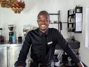 a man in a black shirt and tie in a kitchen at The Bay View Hotel in Richards Bay
