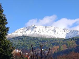 a snow covered mountain in the middle of a forest at Casa La Rubía de Gredos in Cuevas del Valle