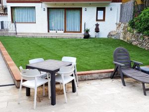 a table and chairs on a patio with a lawn at Casa La Rubía de Gredos in Cuevas del Valle