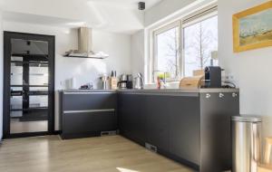 a kitchen with a black counter and a window at Villa Verderop - Luxury Lakeside Villa with Terrace & Water Views in Friesland in Boornzwaag
