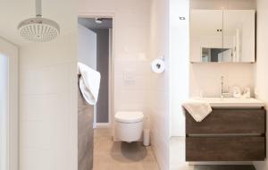 a bathroom with a toilet and a sink at Villa Verderop - Luxury Lakeside Villa with Terrace & Water Views in Friesland in Boornzwaag +34 photos