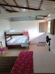 a room with two bunk beds and a red rug at Cabin near the beach in El Valle