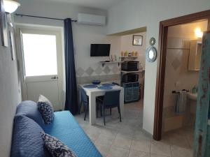 a living room with a blue couch and a table at Appartamenti Conchiglie e Stelle Marine in Cala Gonone +30 photos
