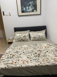 a bed with a comforter and pillows in a bedroom at Riverfront Homestay at Ambience Residence in Malacca
