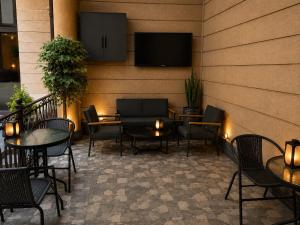 a patio with tables and chairs and a tv on a wall at Republic Square In Hotel California in Yerevan