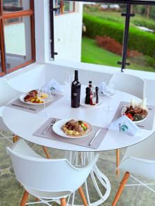 a white table with plates of food and wine glasses at Boynuz Hotels in Nyahururu +6 photos