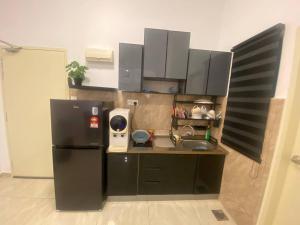 a kitchen with a black refrigerator and a sink at Riverfront Homestay at Ambience Residence in Malacca +12 photos