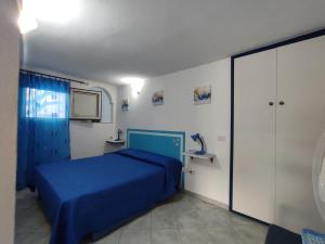 a bedroom with a blue bed and a tv at Appartamenti Conchiglie e Stelle Marine in Cala Gonone
